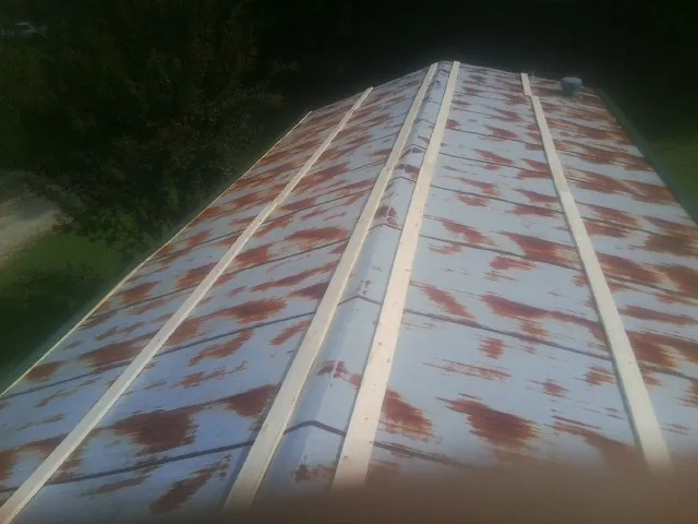 Rusted metal roof panels with new wood purlins before replacement — Storm Damage Roof Repair in Nahant by Roofing Brothers