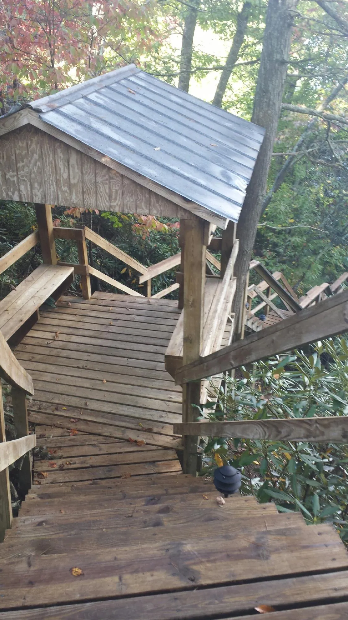 Metal roofed shelter over wooden steps on a wooded walkway — Skylight Repair & Installation work by our crew in Nahant